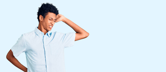 Obraz premium Young african american man wearing casual clothes stretching back, tired and relaxed, sleepy and yawning for early morning