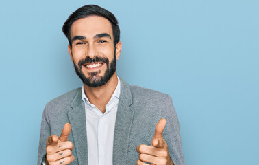 Young hispanic man wearing business clothes pointing fingers to camera with happy and funny face....