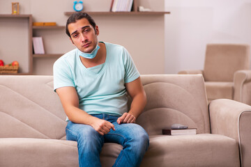 Obraz premium Young man sitting at home during pandemic