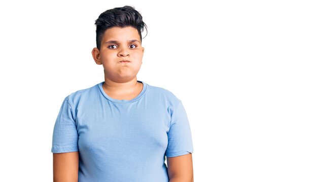 Little boy kid wearing sports workout clothes puffing cheeks with funny face. mouth inflated with air, crazy expression.