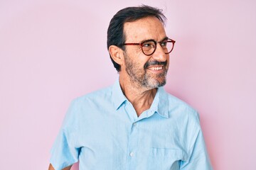 Obraz premium Middle age hispanic man wearing casual clothes and glasses looking to side, relax profile pose with natural face and confident smile.
