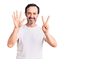 Middle age handsome man wearing casual t-shirt showing and pointing up with fingers number seven while smiling confident and happy.
