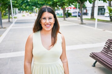Young beautiful woman smiling happy. Standing with smile on face looking at the camera walking at town street.