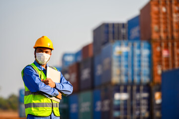 Young Asian male engineer or manager Use of radio communication and laptop computers to control container load in industrial transport and logistics concepts.