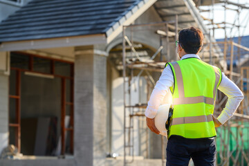 Foreman or young handsome Asian engineer Wear a helmet and a mask Control construction on the construction site