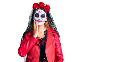 Woman wearing day of the dead costume over background touching mouth with hand with painful expression because of toothache or dental illness on teeth. dentist
