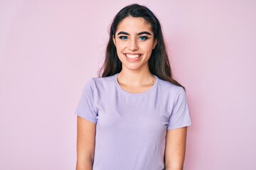Fototapeta premium Brunette teenager girl wearing casual clothes looking positive and happy standing and smiling with a confident smile showing teeth