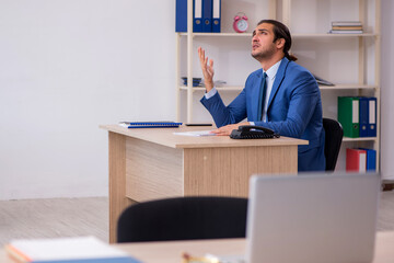 Young male employee and too much work in the office