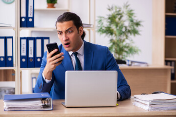 Young handsome employee sitting in the office