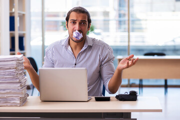 Young male employee unhappy with excessive work in the office