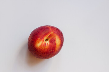 Whole ripe nectarine on gray surface, top view