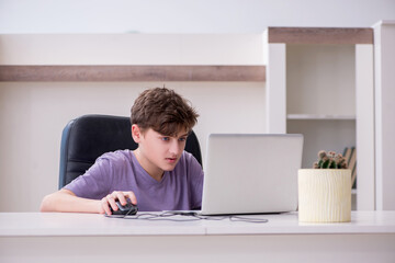 Schoolboy playing computer games at home