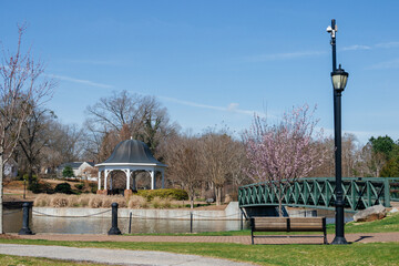 A beautiful park with a large pond and a beautiful gazebo among flowering trees. Cleveland Park in Spartanburg, SC, USA on a sunny spring day.