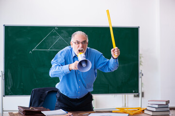 Angry aged male math teacher holding megaphone