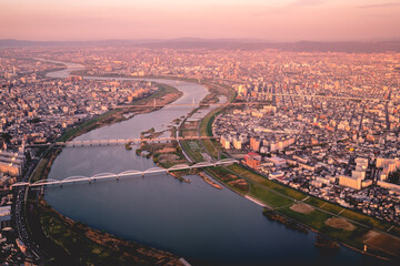 Panoramic view of sunset over Osaka cityscape and Yodo River, Japan