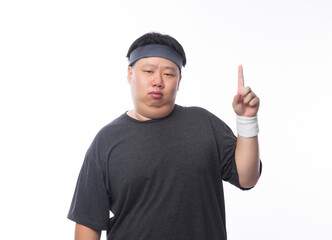 Young Asian funny fat sport man poiting to copy space isolated on white background.