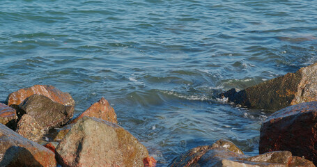 Big sea waves splash against rock on island