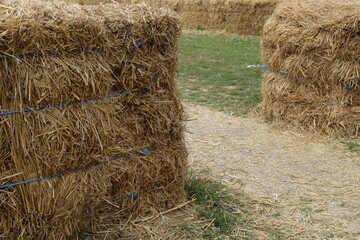 Hay bales being used for crowd control, with a pathway between two bales