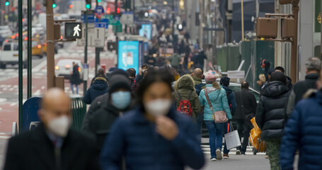 Anonymous crowd of people walking street wearing masks