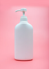 White plastic pump bottle for skin care cosmetics on pink background