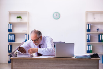 Old male employee working in the office