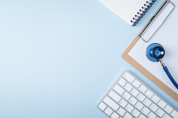 Doctor workplace. Stethoscope and computer keyboard on blue office desk top view copy space