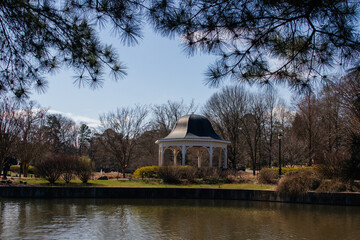 A beautiful park with a large pond and a beautiful gazebo among flowering trees. Cleveland Park in Spartanburg, SC, USA on a sunny spring day.