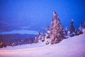 Beautiful night cold scandinavian mountain view of ski resort, sunny winter day with slope, piste...