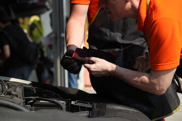 hand of a mechanic at work in his garage or car repair service or auto store, business, maintenance and people concept