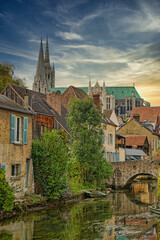 Vertical shot of the Eure River with old houses and Notre-Dame de Chartres Cathedral in France
