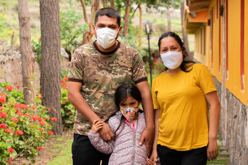 Portrait of two parents with their daughter and with mask