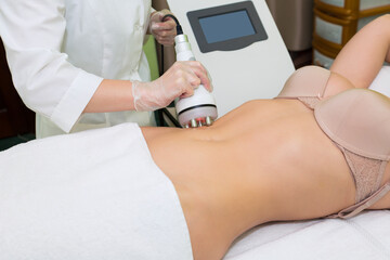 A Russian lifting specialist performs a body shaping procedure for a young woman.