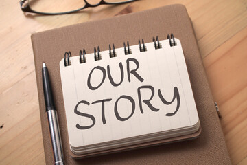 Our story, text words typography written on book against wooden background, life and business motivational inspirational
