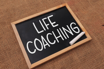 Life coaching, text words typography written on chalkboard against wooden background, life and business motivational inspirational