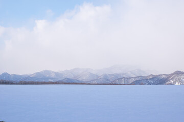 Snow-covered mountains and flowing clouds in Hokkaido, Japan