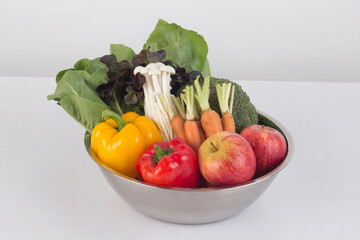 vegetables and fruits in stainless steel bowl isolated on white background