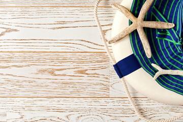 Beach accessories with blue hat, lifebuoy, sea creatures on the wooden surface. Copy space for advertisement text. Holidays backgrounds and textures