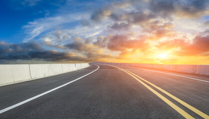 Naklejka premium Asphalt road and sky clouds at sunset.Road background.
