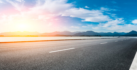 Asphalt road and mountain with sky clouds at sunset.