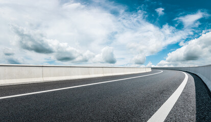 Fototapeta premium Empty asphalt road and blue sky with white clouds.Road background.