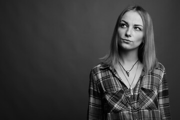 Young beautiful rebellious woman with dyed hair against gray background