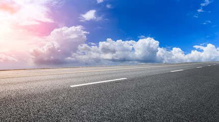 Fototapeta premium Empty asphalt road and blue sky with white clouds.Road background.