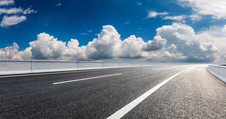 Fototapeta premium Empty asphalt road and blue sky with white clouds.Road background.