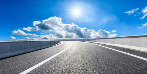 Fototapeta premium Empty asphalt road and blue sky with white clouds.Road background.