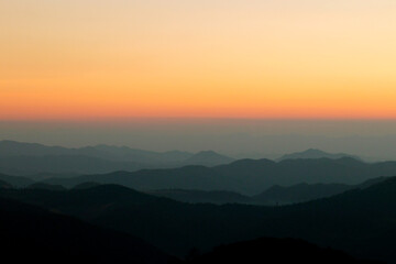 Panoramic view of mountains, autumn landscape with foggy hills at sunrise.