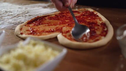 fresh raw pizza in the shape of a heart lies on the table, red sauce on top. Fast food concept for valentine's day