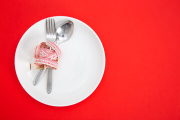 Measuring tape on a fork and knife - diet concept