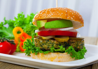 Tasty burger with vegan cutlet, pickled cucumbers