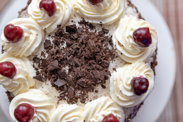 Black forest cherry cake close-up. Sponge cake with chocolate and cherries.