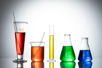 Variety of glass flasks and lab equipment with colorful liquids on a table